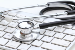 Stethoscope isolated on white with a modern computer keyboard